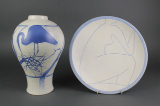 A cream glazed Studio Pottery oviform vase, the blue ground decorated a heron building its nest 12", a ditto dish decorated with a naked female figure 12"