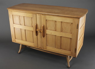 An Ercol light elm sideboard, the interior fitted 2 drawers enclosed by a pair of panelled doors, raised on out swept supports 33"h x 48 1/2"w x 18"d 