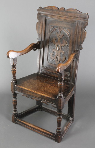 A Victorian carved oak Wainscot chair with carved back and solid seat, raised on turned and block supports 