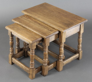 A nest of 3 rectangular oak interfitting coffee tables, raised on turned and block supports, largest 18"h x 23"w x 13"d, middle 17"h x 18 1/2"w x 12"d, smallest 16"h x 15"w x 9"d 