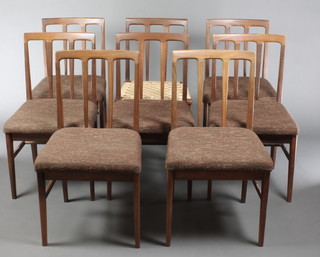 In the manner of Younger, a set of 8 teak stick and rail back dining chairs 