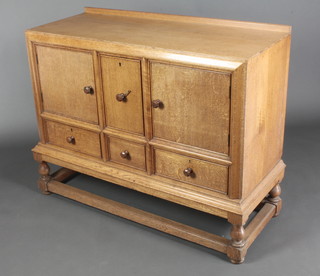 A Heal's Art Deco light oak sideboard with raised back, fitted a cellarette drawer to the centre flanked by a cupboards enclosed by panelled doors, the base fitted 1 short and 2 long drawers with octagonal turned handles, raised on turned and block supports 39"h x 47"w x 19"d 