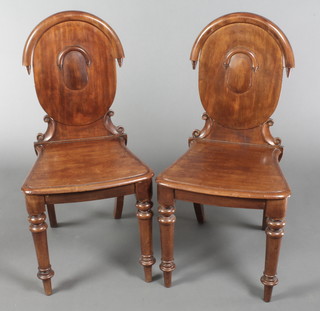 A pair of Victorian mahogany hall chairs with solid seats, raised on turned supports 