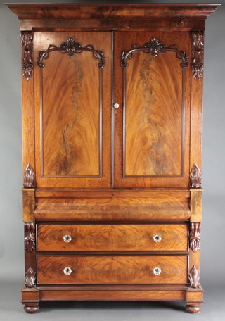 A Victorian mahogany linen press with moulded cornice, the interior fitted 2 shelves enclosed by arched panelled doors, the base fitted a secret drawer above 2 long drawers with glass handles and having vitruvian scrolls to the side 94"h x 62"w x 28"d 