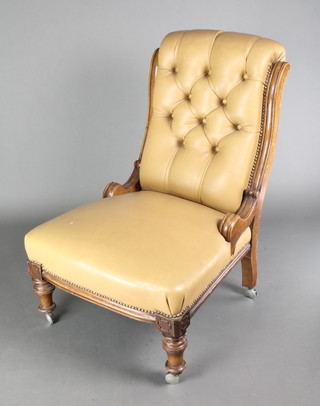 A Victorian mahogany show frame nursing chair upholstered in brown buttoned rexine on turned supports