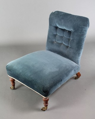 A Victorian nursing chair upholstered in blue Dralon, raised on turned supports 