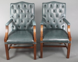 A  pair of mahogany framed Georgian style library chairs upholstered in blue material, raised on square supports with H framed stretcher 