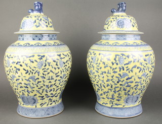 A pair of Chinese porcelain blue and yellow jars and covers with dog of fo finials 13" 