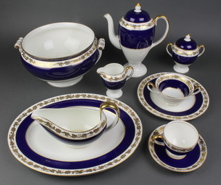 A 115 piece Wedgwood blue and gilt banded dinner/tea service comprising 2 twin handled tureens, bowl, 8 meat plates (1 chipped), 21 dinner plates, 18 side plates, 17 further side plates (3 cracked, 1 discoloured), 6 tea plates (1 cracked, 2 discoloured), 3 sauce boats and stands (1 boat and stand cracked), coffee pot, cream jug, lidded sucrier, bowl, 5 coffee cans, 12 coffee saucers (2 cracked), 14 tea cups, 15 saucers, 6 further saucers, 6 twin handled soup bowls (2 cracked) and 2 associated lid 