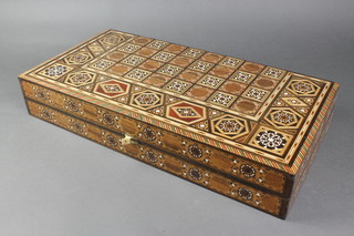 A Moorish style inlaid mahogany games compendium, the top inlaid a chessboard, the interior inlaid a backgammon board 