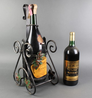 A 3 litre bottle of 1983 Italian Barolo contained in an iron cradle together with a 150cl bottle of 1986 Bordeaux Chateau Bellevue La Selourde