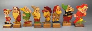 7 1930's painted wooden 7 Dwarf figures, the bases marked C A Scrase, 4 1/2" and a ditto Pinocchio figure 