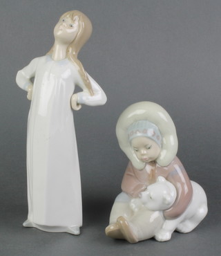 A Lladro figure of a standing girl with hands on hips 8" and a ditto seated girl with polar bear 4" 