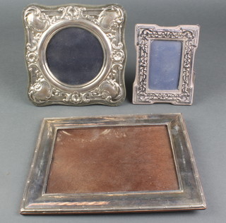 A repousse silver rectangular photograph frame, London 1985 5 1/2" x 4" and 2 others