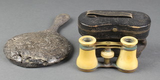 A repousse silver hand mirror and a cased pair of opera glasses