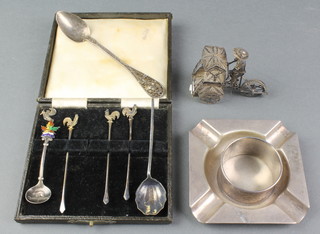 An Art Deco silver ashtray 114 grams, a Chinese silver figure of a man riding a tricycle, 3 spoons, a napkin ring and 3 cocktail sticks 