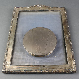 A rectangular silver photograph frame with repousse scroll decoration, Birmingham 1923, 10", a silver jar lid 