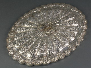 A Persian repousse silver oval mirror, the back with floral decoration and a stylised bird handle 13" 