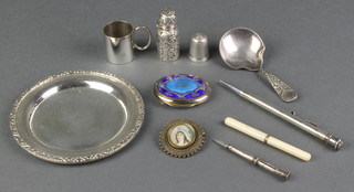 A Continental circular silver nut dish, a caddy spoon, miniature mug and minor curios 