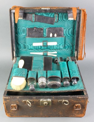 A leather toilet case containing 4 Victorian silver mounted bottles Birmingham 1898, minor accessories 