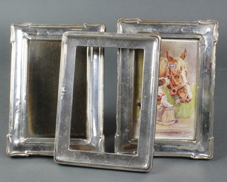 A pair of rectangular silver photograph frames with repousse decoration Birmingham 1918 7" x 5", a plain ditto 