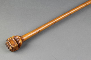A 19th Century naive carved walking cane, the grip in the form of a hand clasping a brick 