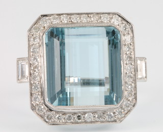 An 18ct white gold aquamarine and diamond dress ring, the centre stone approx. 23 cts surrounded by 33 brilliant cut diamonds and 2 baguette cut diamonds, size O