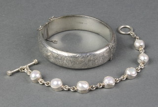 A hollow silver bangle and a baroque pearl set silver bracelet