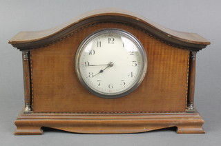 A French bedroom timepiece with enamelled dial and Roman numerals contained in a walnut arch shaped case 