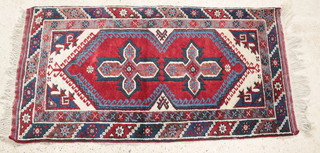 A Persian rug with blue and white ground, diamond design to the centre, 51" x 27" 
