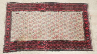 A Baluch red and white ground rug with hooked design to the centre 67" x 42" 