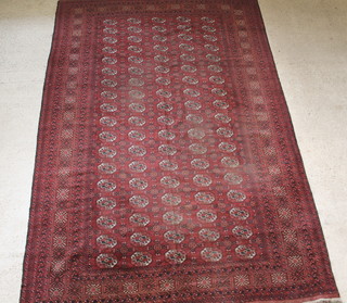 A Turkmen red ground carpet with 90 octagons to the centre 159" x 106", some wear 