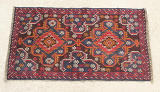 A Belouche brown and red ground rug with 2 stylised diamonds to the centre 57" x 32"