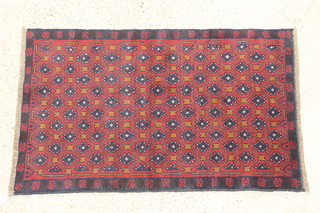 A Persian Belouch red and blue ground  rug with all-over geometric design 52" x 32"