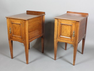 A pair of Edwardian inlaid mahogany bedside cabinets with raised backs, enclosed by panelled doors, raised on square tapering supports 30"h x 16"w x 21"d 