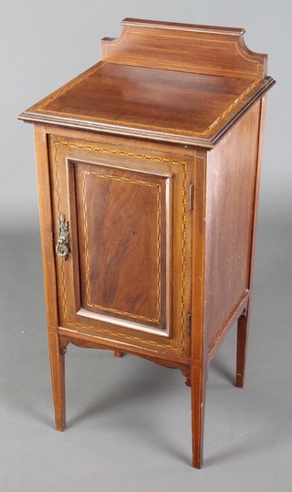 An Edwardian inlaid mahogany bedside cabinet with raised back, the cupboard enclosed by panelled doors, raised on tapered supports 34"h x 16"w x 15"d 
