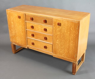 Gordon Russell, a light oak sideboard fitted 4 long drawers flanked by a pair of cupboards, raised on square supports 36"h x 54"w x 18"d, there is a Russell of Broadway label to the back 