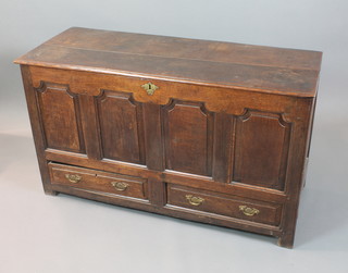 An 18th Century oak mule chest of panelled construction with hinged lid, the front fitted 4 arched panels above 2 long drawers, with iron lock and brass escutcheon 30"h x 53"w x 21"d 