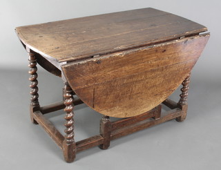 An 18th Century oval oak gateleg drop flap dining table, the centre section formed of 3 planks and raised on spiral turned supports 28 1/2"h x 48" x 24" when closed x 60" when full extended