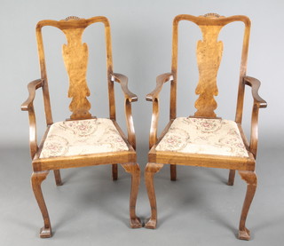 A pair of Queen Anne style walnut splat back carver chairs on cabriole supports