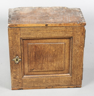 An 18th Century oak cabinet, the interior fitted 2 long drawers above a recess flanked by 4 short drawers with 1 long drawer beneath, enclosed by a panelled door with iron H framed hinges 16"h x 15"w x 8 1/2"d 
