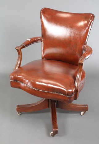 A 1930's mahogany revolving office chair upholstered in brown leather 