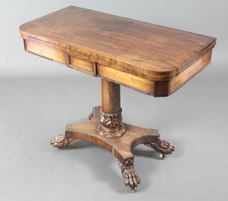 A Regency rosewood  D shaped card table, raised on a turned column and tripod base with paw feet 30"h x 36"w x 18"d 