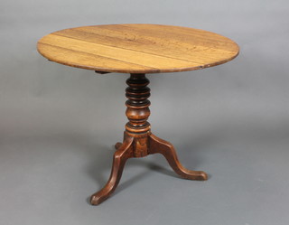 A Georgian country elm snap top tea table raised on ring turned column and tripod base 28"h x 36" diam.