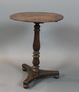 A William IV oval mahogany snap top wine table, raised on a turned column with triform base 26"h x 21 1/2"w x 18"d 