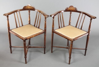 A pair of Edwardian inlaid mahogany stick and rail back corner chairs on turned supports with X framed stretcher 