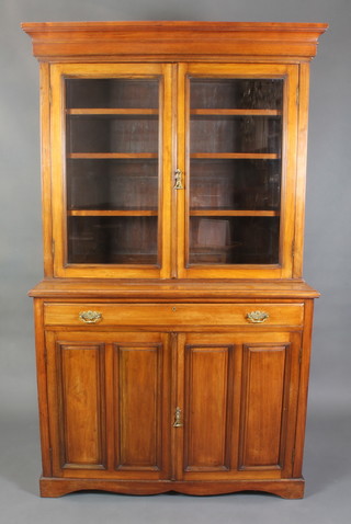 A Victorian walnut secretaire bookcase on cabinet, the upper section with moulded cornice, fitted shelves enclosed by glazed panelled doors, the base fitted a secretaire drawer above a cupboard enclosed by a panelled door and raised on a platform base 83"h x 50"w x 19"d 