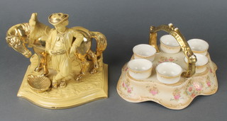 A Crown Devon Fieldings 6 piece egg cup holder with floral decoration 10", a German gilt and tan glazed figure of a man standing beside a horse 