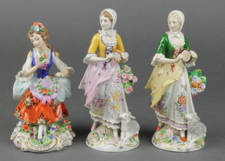 A pair of early 20th Century Sitzendorf figures of shepherdesses holding tambourines, on raised rococo bases 6 1/2", a ditto figure of a seated lady with a bonnet on her lap 5" 
