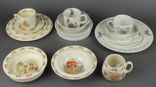 Items of Royal Doulton Bunnykins table china comprising 2 side plates 8", tea plate 7", cup and saucer, pudding bowl and cereal bowl and mug, together with 7 items of Wedgwood Peter Rabbit nursery ware comprising dinner plate 10", side plate 7", cup and saucer, cereal bowl, pudding bowl and mug 
